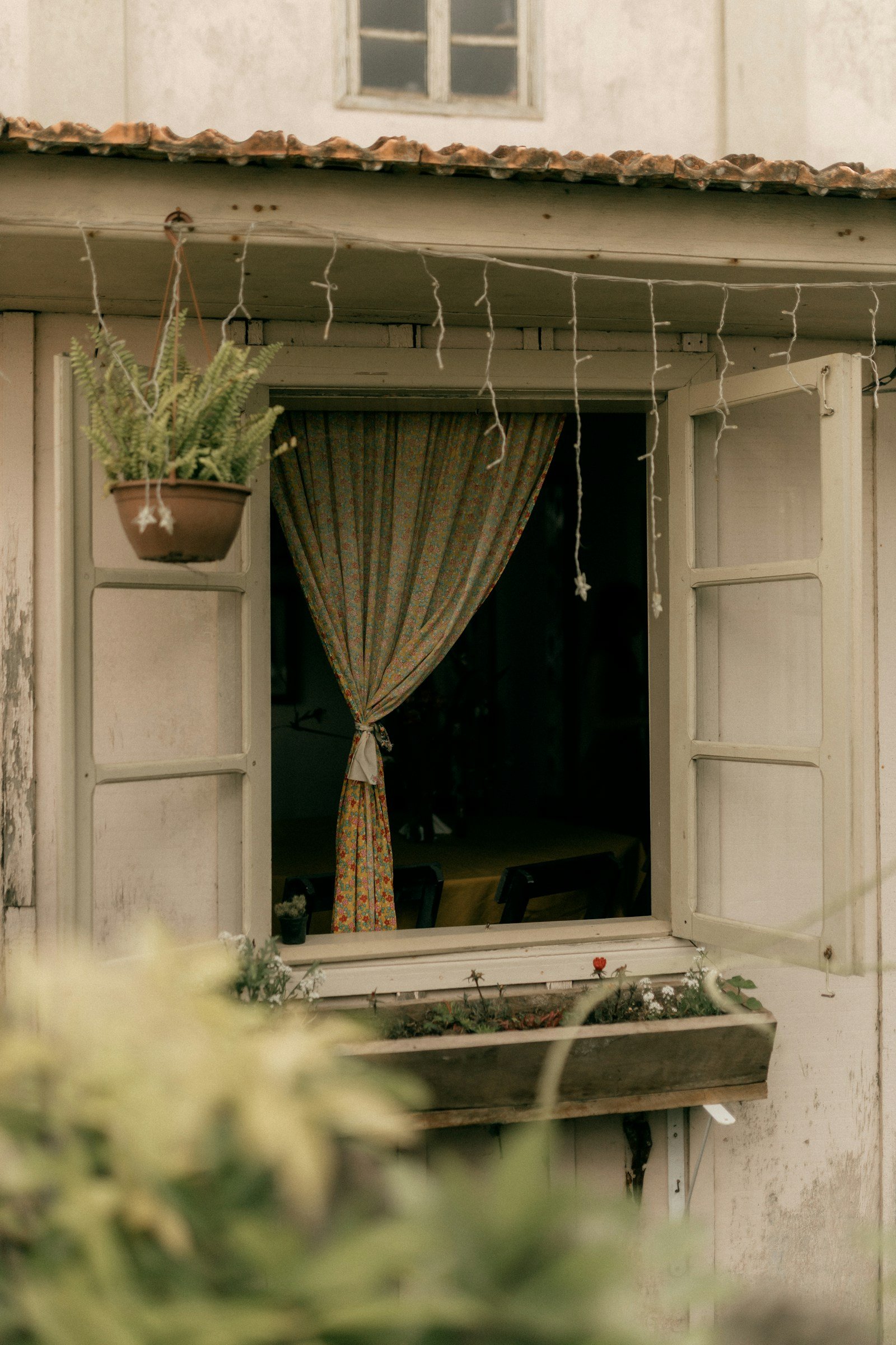 Fenêtre ouverte avec rideaux et plantes en pot sur le rebord